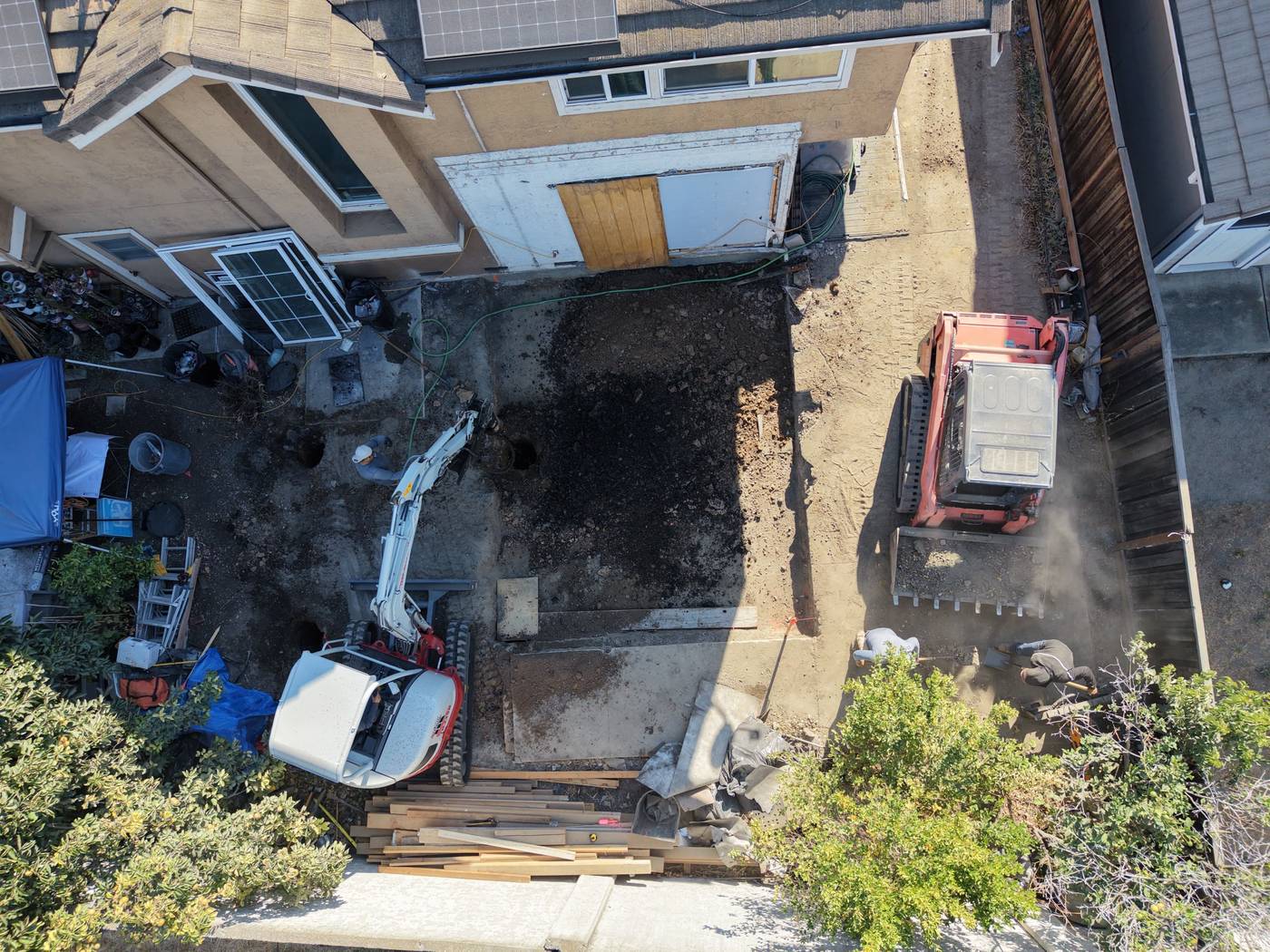 Mini-excavator digging an addition footing to grade in Milpitas