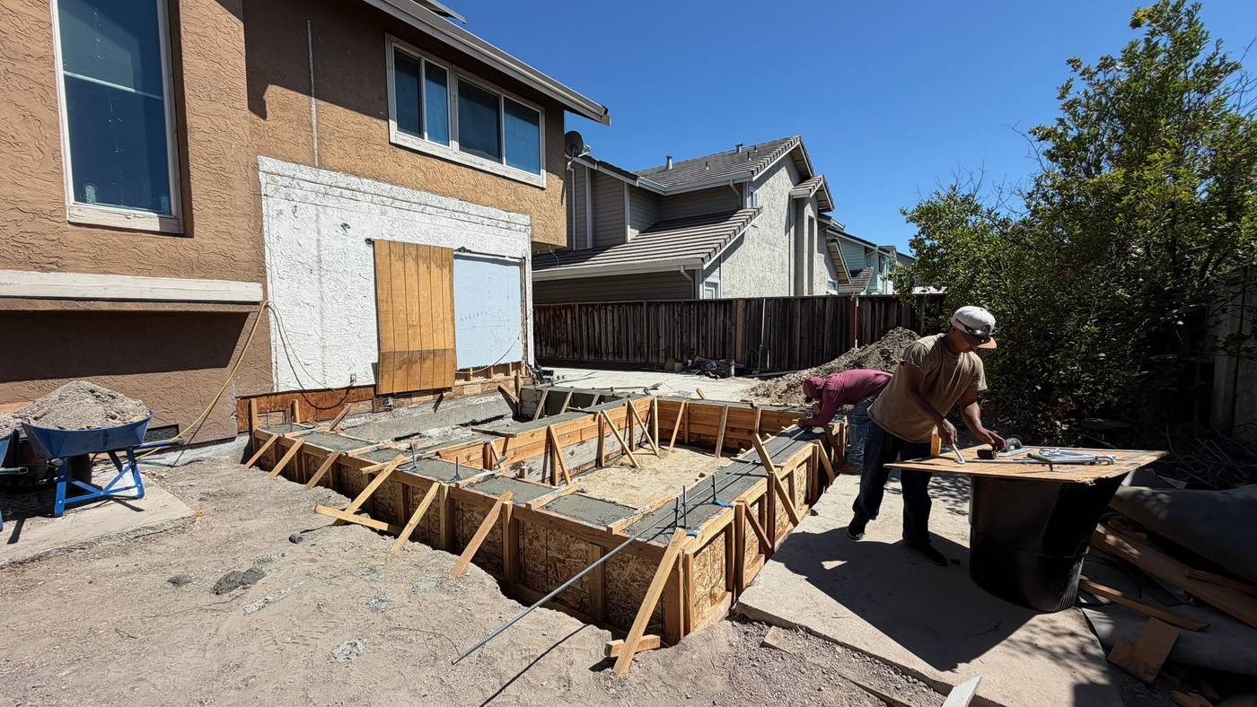 Crew setting concrete forms for a home addition footing in Milpitas