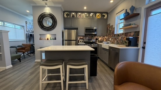 Completed ADU kitchen with stainless appliances, quartz island and tile backsplash