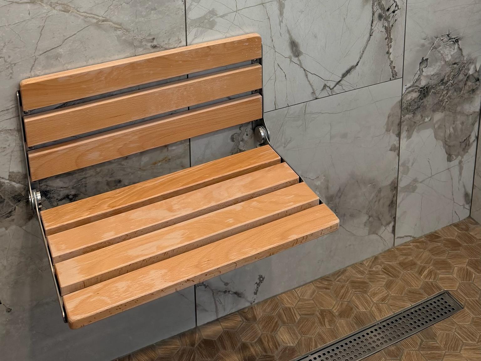 Finished walk-in shower in San Jose with slab porcelain walls, a teak fold-down bench and a linear drain