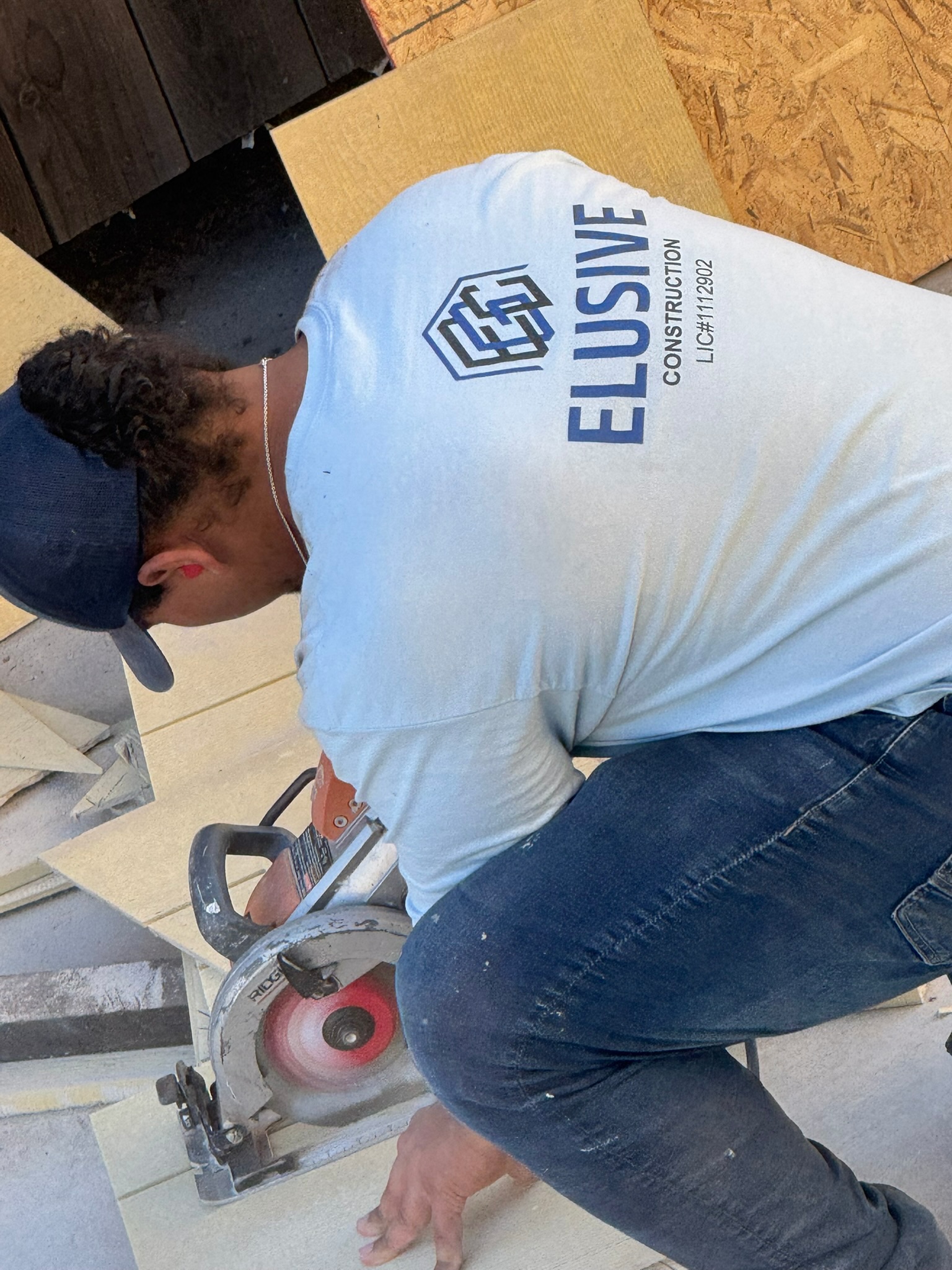Elusive Construction crew member cutting fiber cement siding with a circular saw on a San Jose jobsite