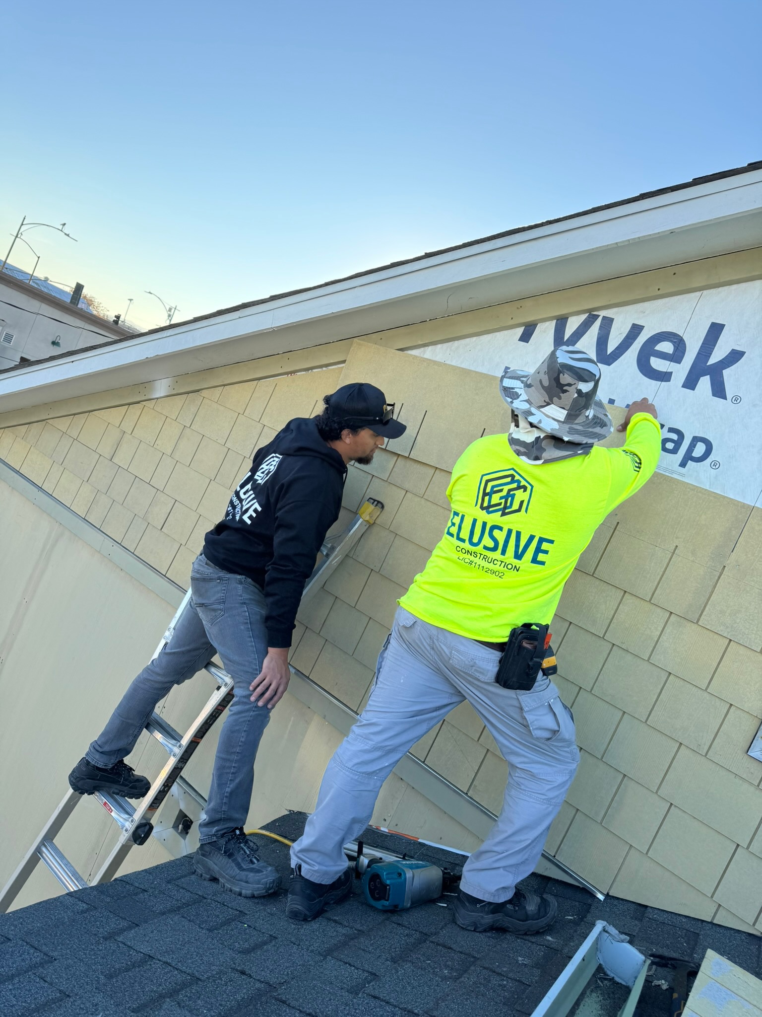 Two Elusive Construction crew members installing siding over Tyvek on a San Jose house