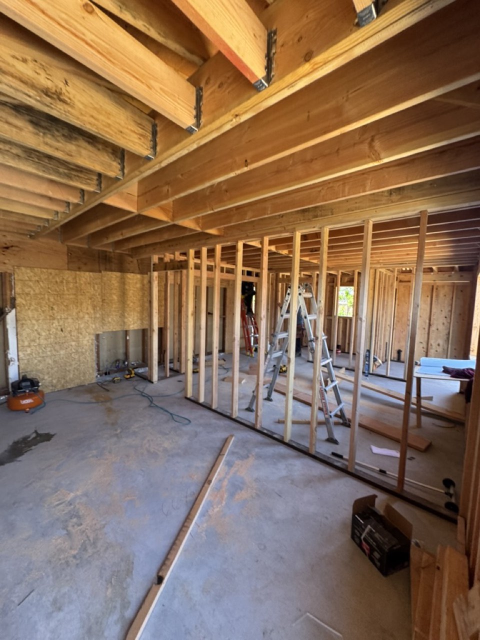 Interior framing of a San Jose garage conversion showing new stud walls and existing ceiling joists