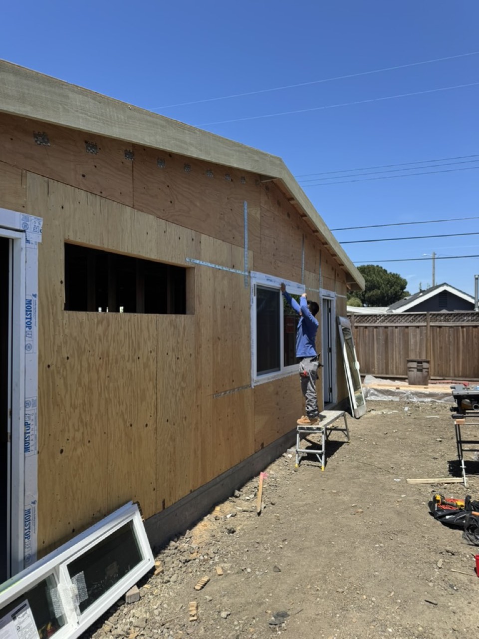 Exterior plywood sheathing with a window being installed on a San Jose garage conversion ADU