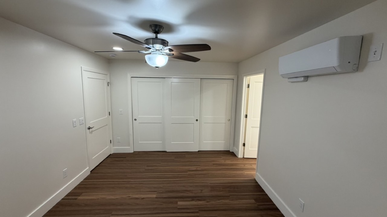 Finished ADU bedroom in San Jose with wood-look flooring, closet and ductless mini-split