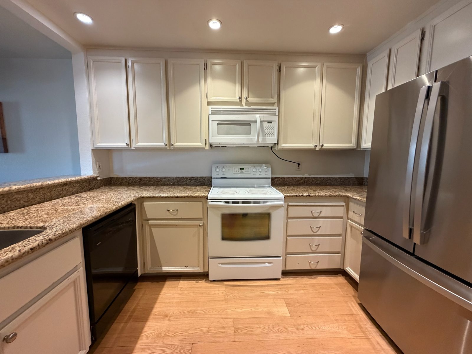 Range wall of the kitchen before the refresh, with white appliances and speckled counters