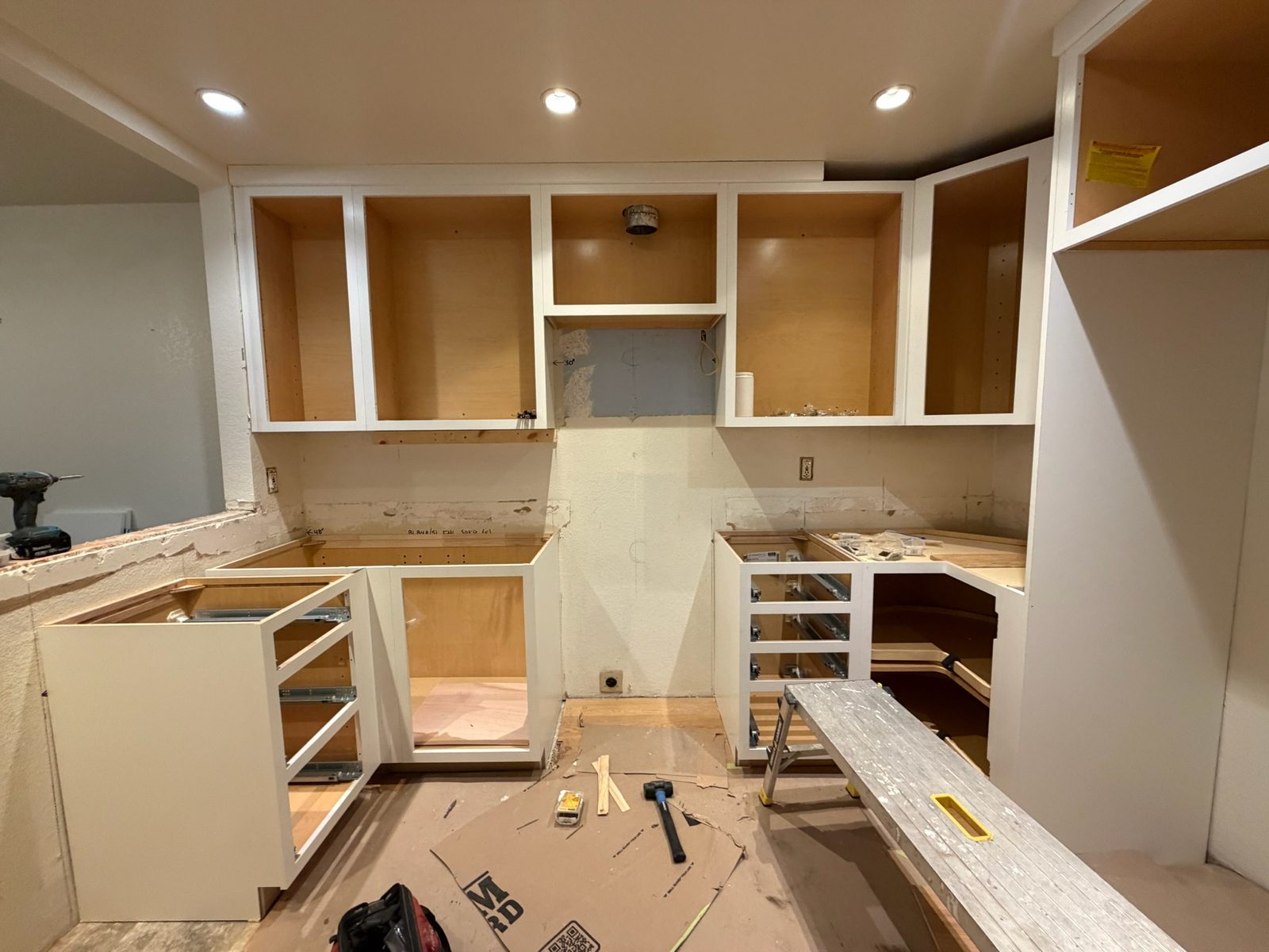 New white cabinet boxes installed around the kitchen before doors and counters