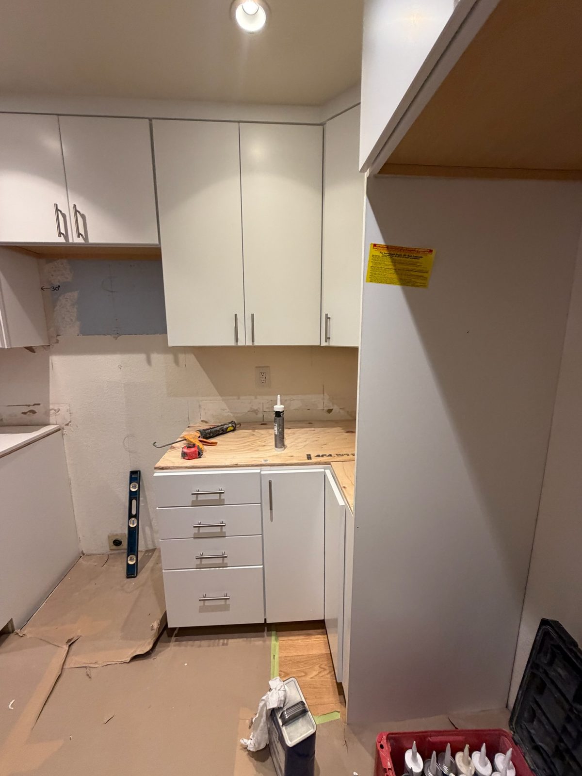 White flat-panel cabinet doors installed, with the counters not yet in