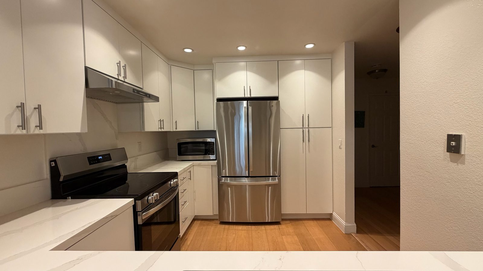 Finished kitchen looking toward the refrigerator and the full-height pantry cabinets