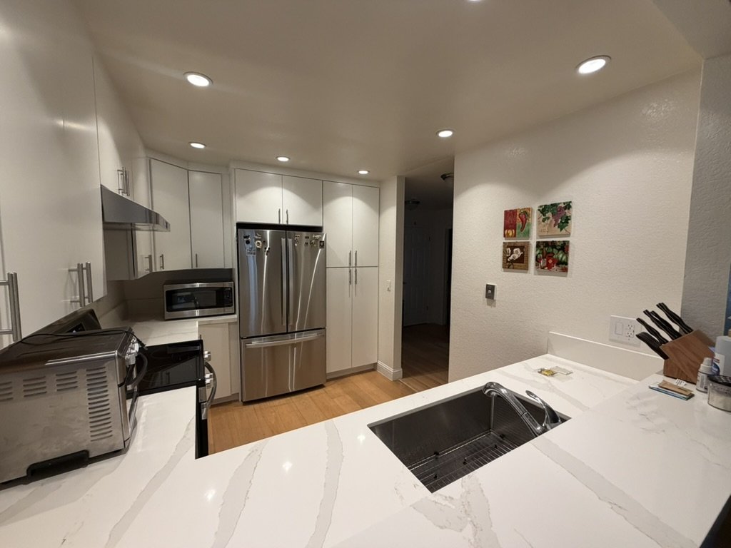 Finished kitchen looking from the peninsula toward the hallway, with the undermount sink in the foreground