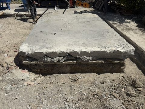 Broken edge of an unengineered concrete slab bearing on loose soil